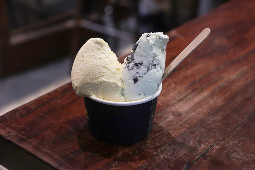 Split single scoop of Queenslanda gelato and After Dinner Mint gelato in a takeaway cup